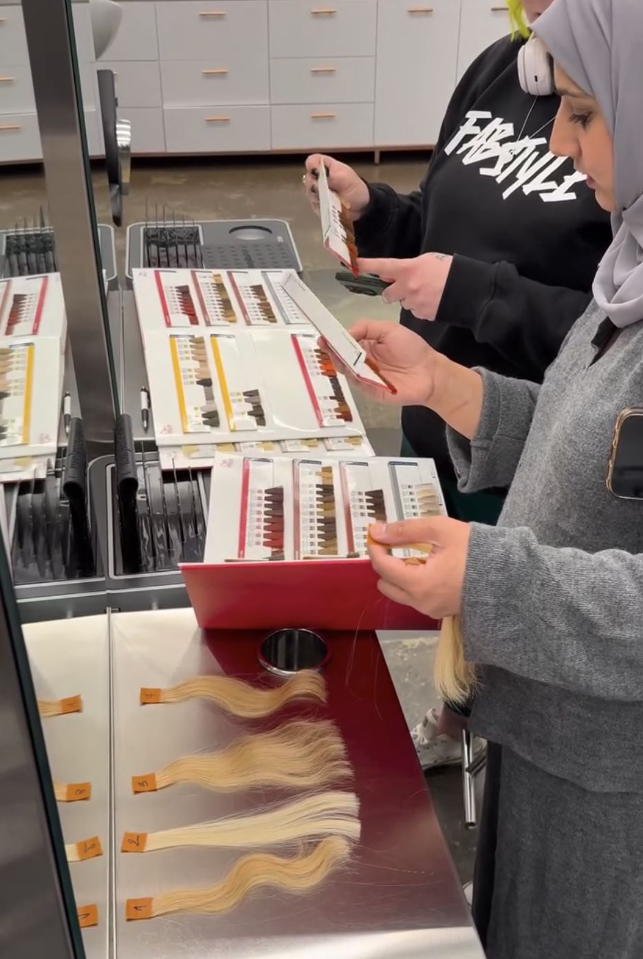 Participants comparing professional hair colour swatches during a hands-on session